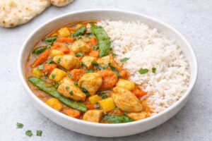 Red Thai chicken curry made with chicken breast, coconut milk, pineapple, snow peas, carrots, and rice