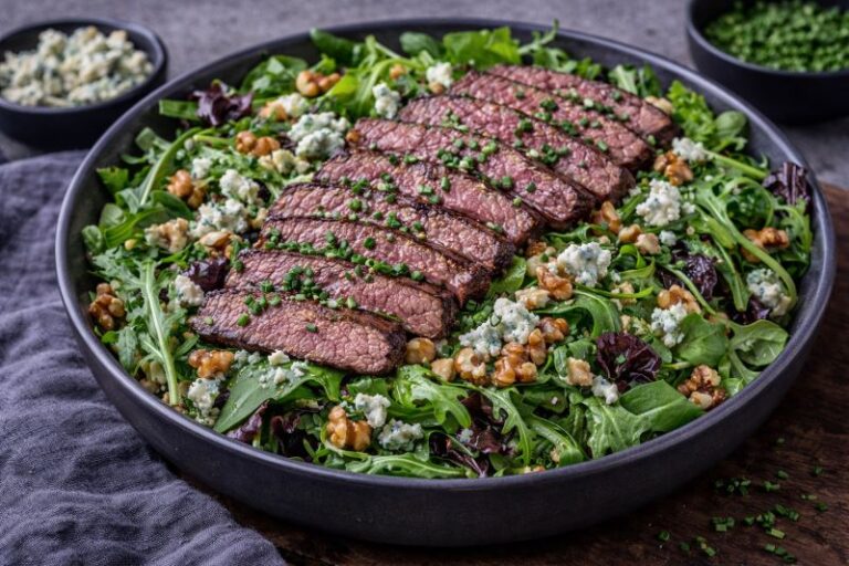 steak salad with blue cheese walnuts and sliced steak over greens